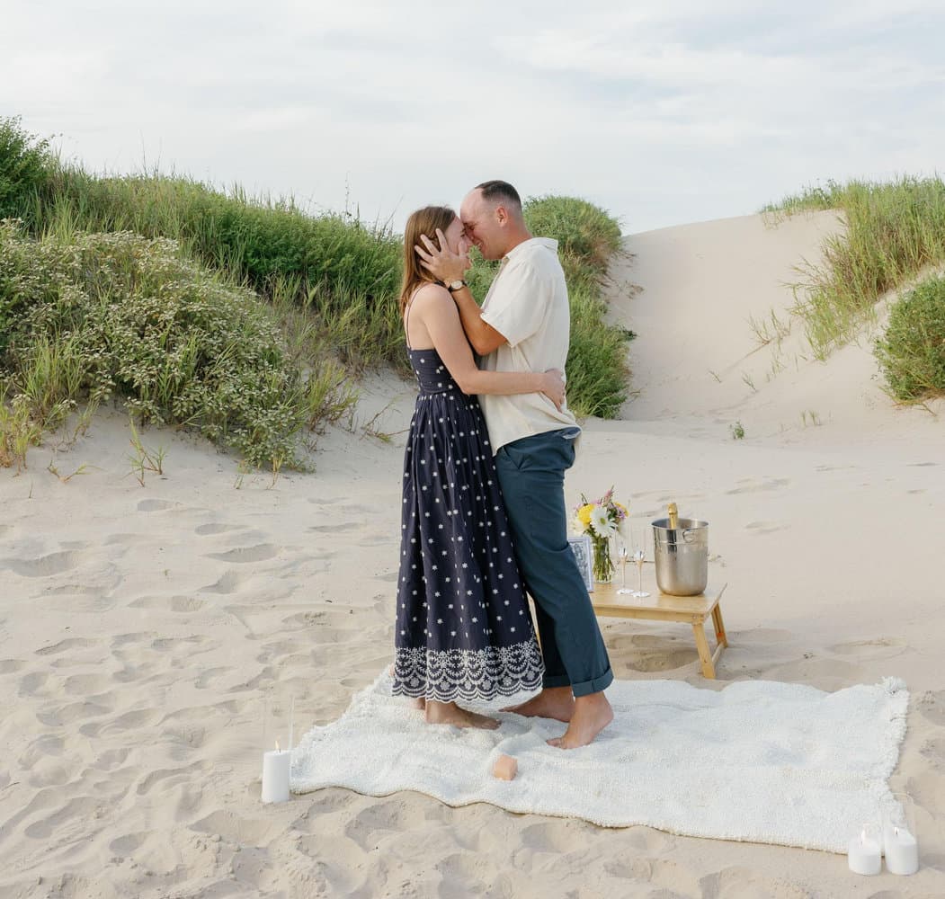 Nicole and Tyler kissing on the sand dunes after their engagement